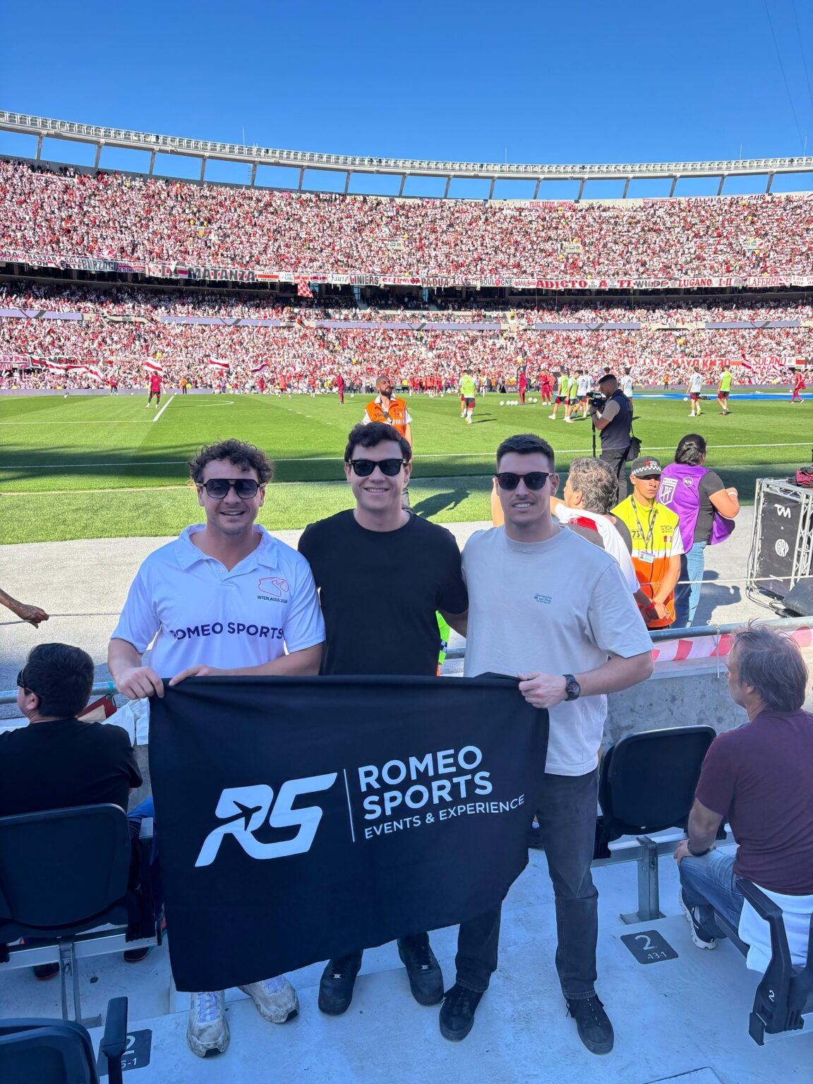 Equipo de Romeo Sports con su bandera en el estadio