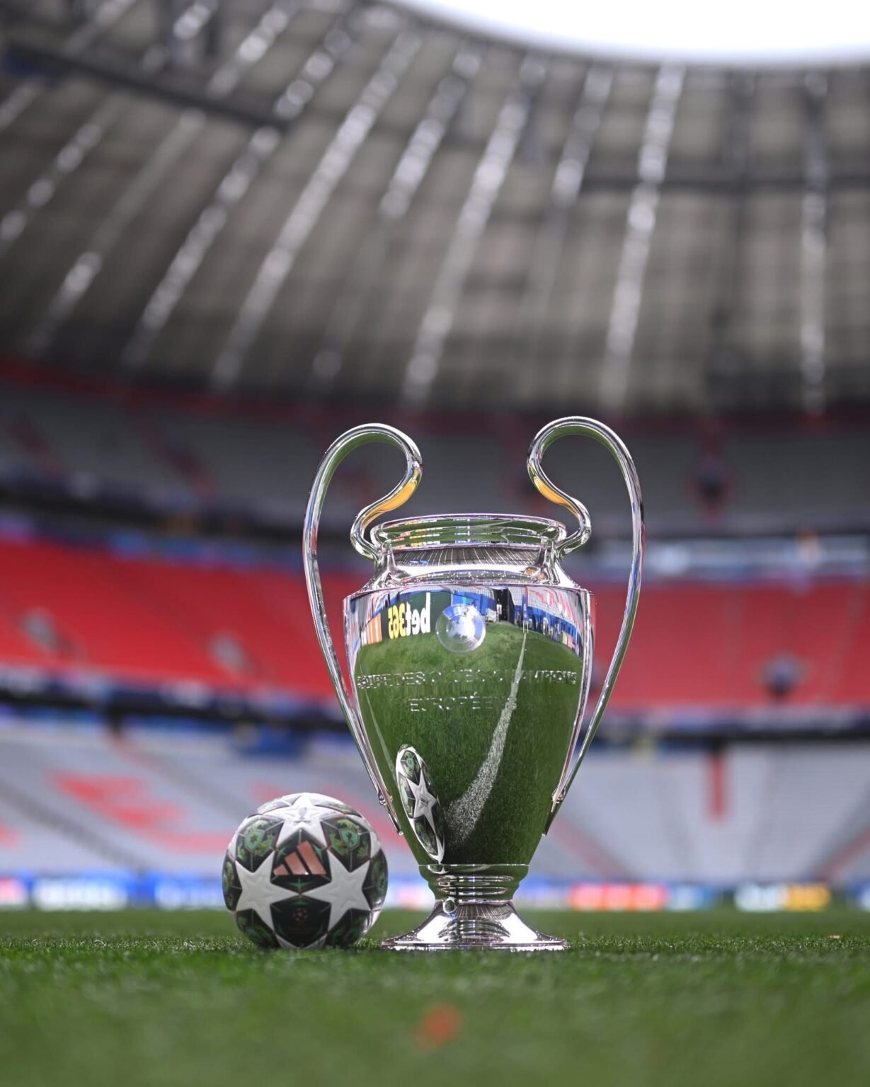El trofeo de la Champions League y el balón oficial sobre el césped